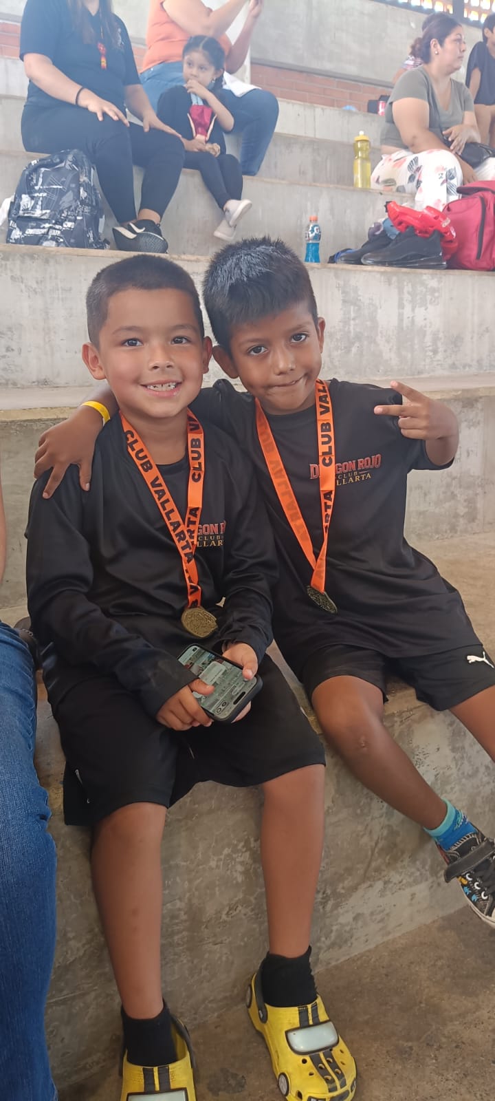 Two young martial arts participants wearing medals