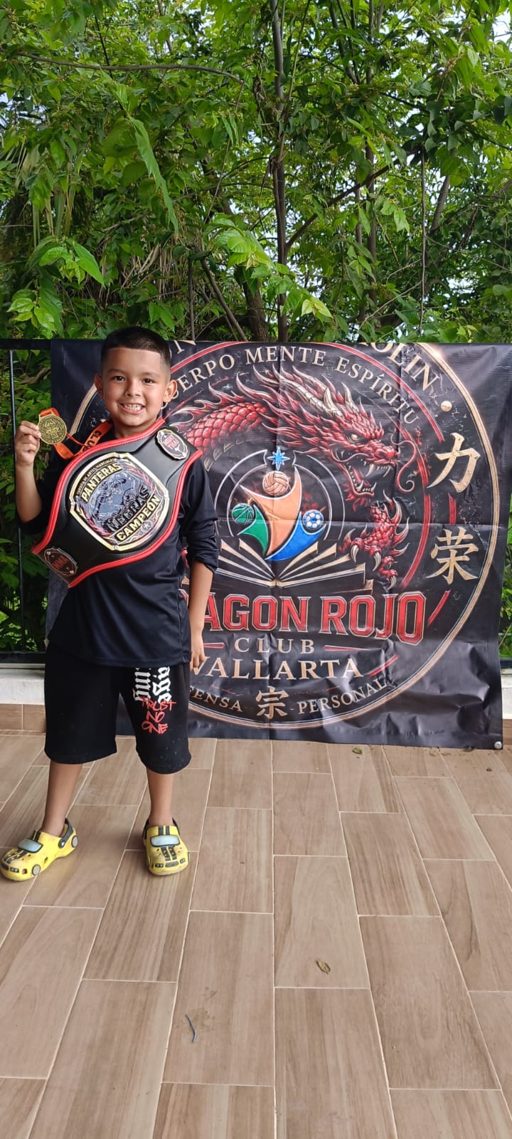 Young martial arts participant posing with a banner
