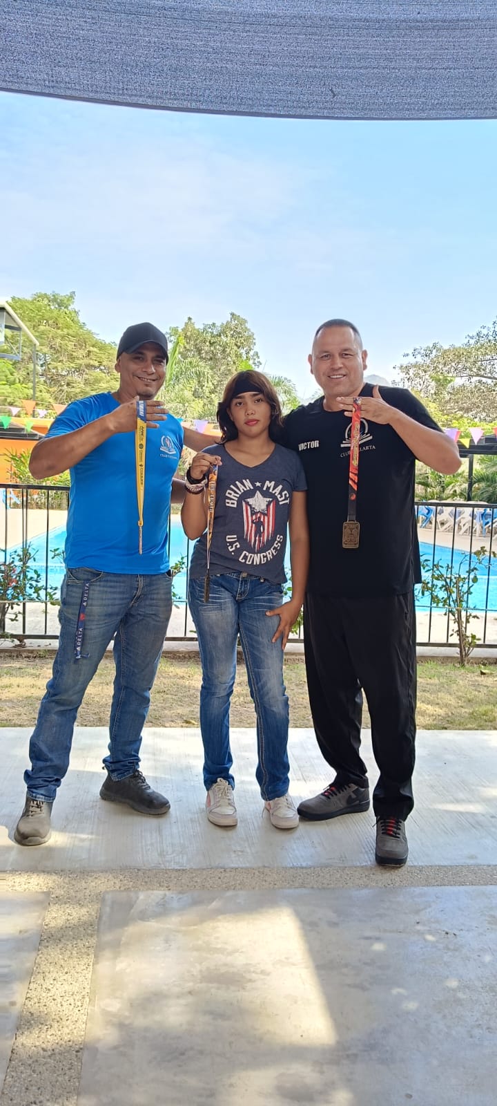 Martial arts participants posing with an instructor near an awards display