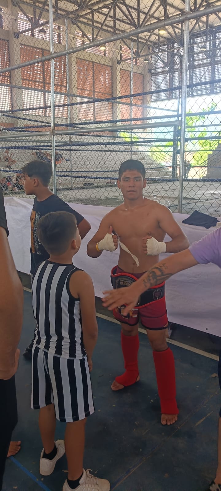 Martial arts participants posing with championship belts