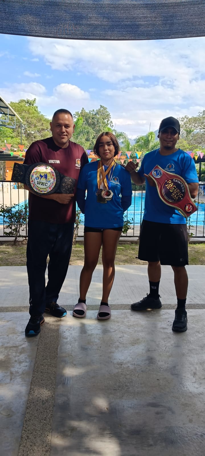 A martial arts participant posing near the awards display